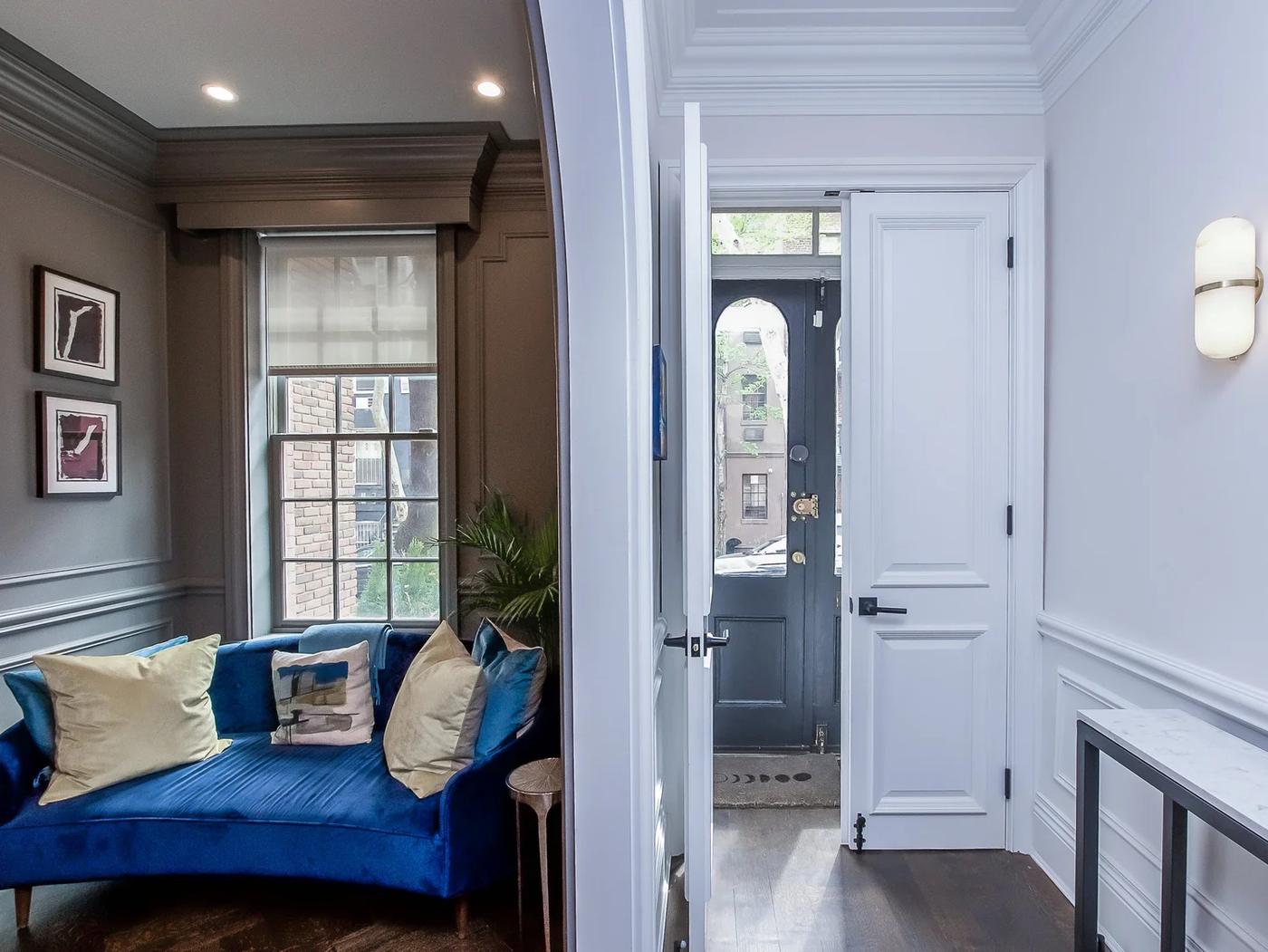 Paneled sitting room with marble fireplace and arched opening, Upper East Side townhouse