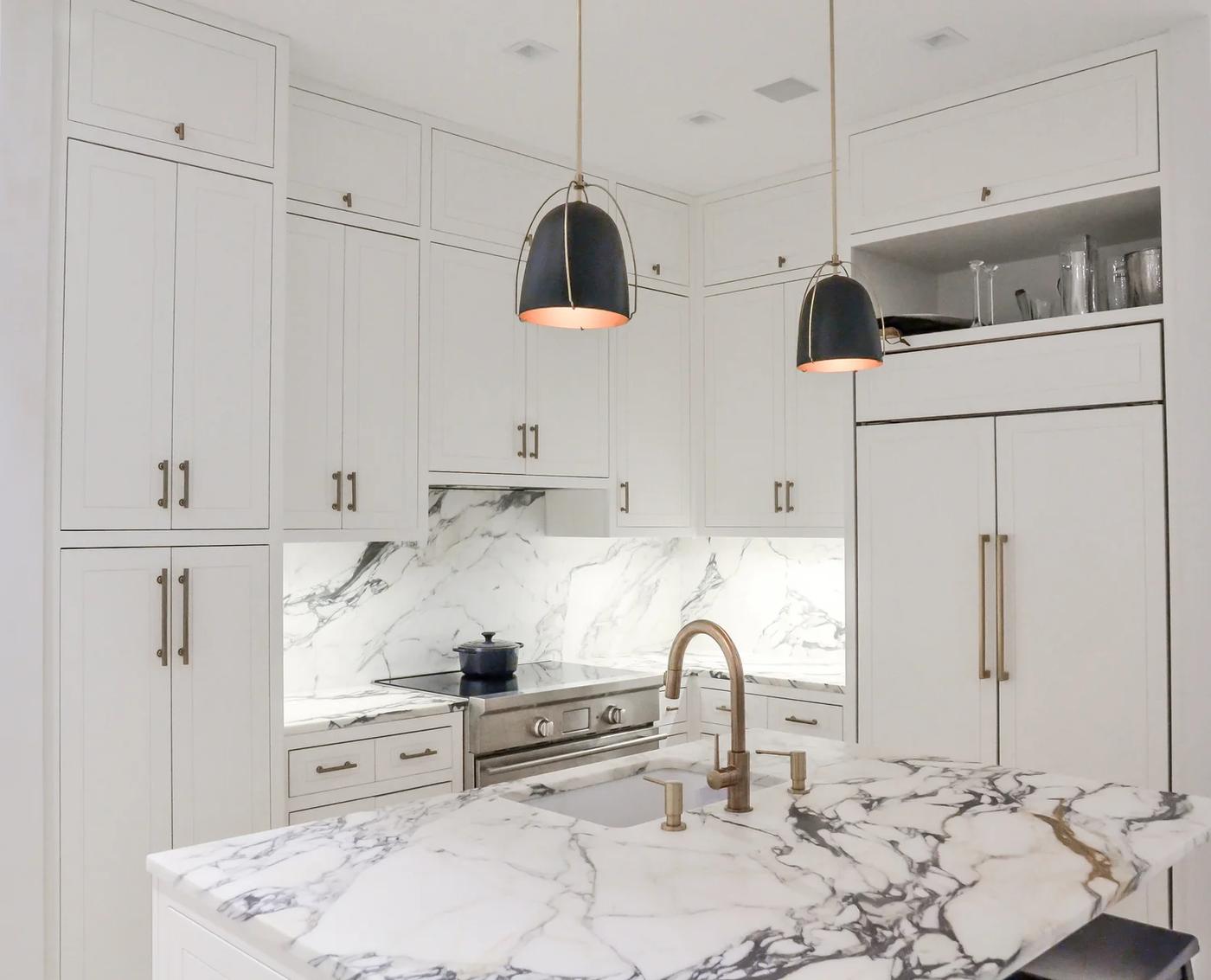 White kitchen with book-matched marble island and brass fittings, Mercer Street SoHo