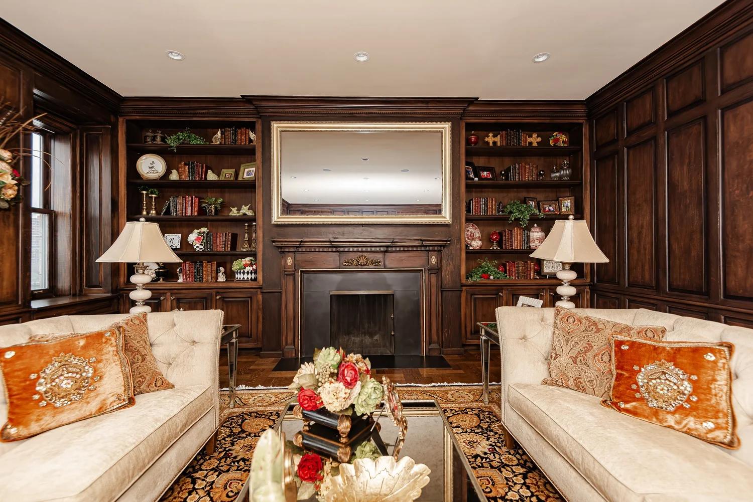 Walnut-paneled library with fireplace at 1 East End Avenue