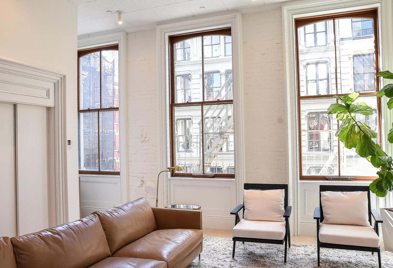 Sunlit SoHo loft living room with tall windows